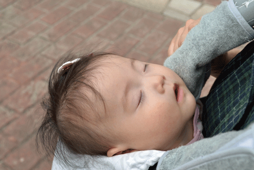 赤ちゃんが抱っこひもで寝ている画像
