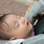 赤ちゃんが抱っこひもで寝ている画像