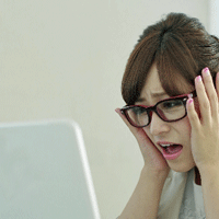 パソコンを見るメガネをかけた女性が困っている画像