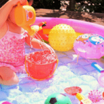 子供用プールで女の子が遊ぶ画像