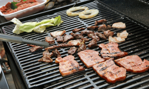 バーベキューでお肉と野菜を焼いている画像