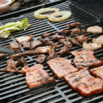 バーベキューでお肉と野菜を焼いている画像